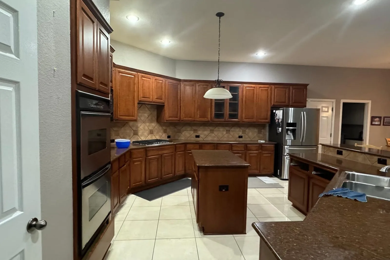 North Austin kitchen before the remodel, dark wood cabinetry and tile floors