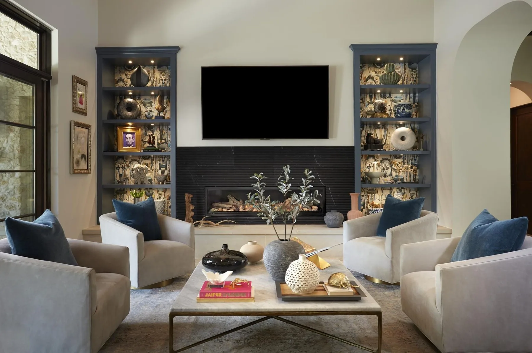 Spanish Oaks living room with a dark fireplace wall and art-filled built-ins