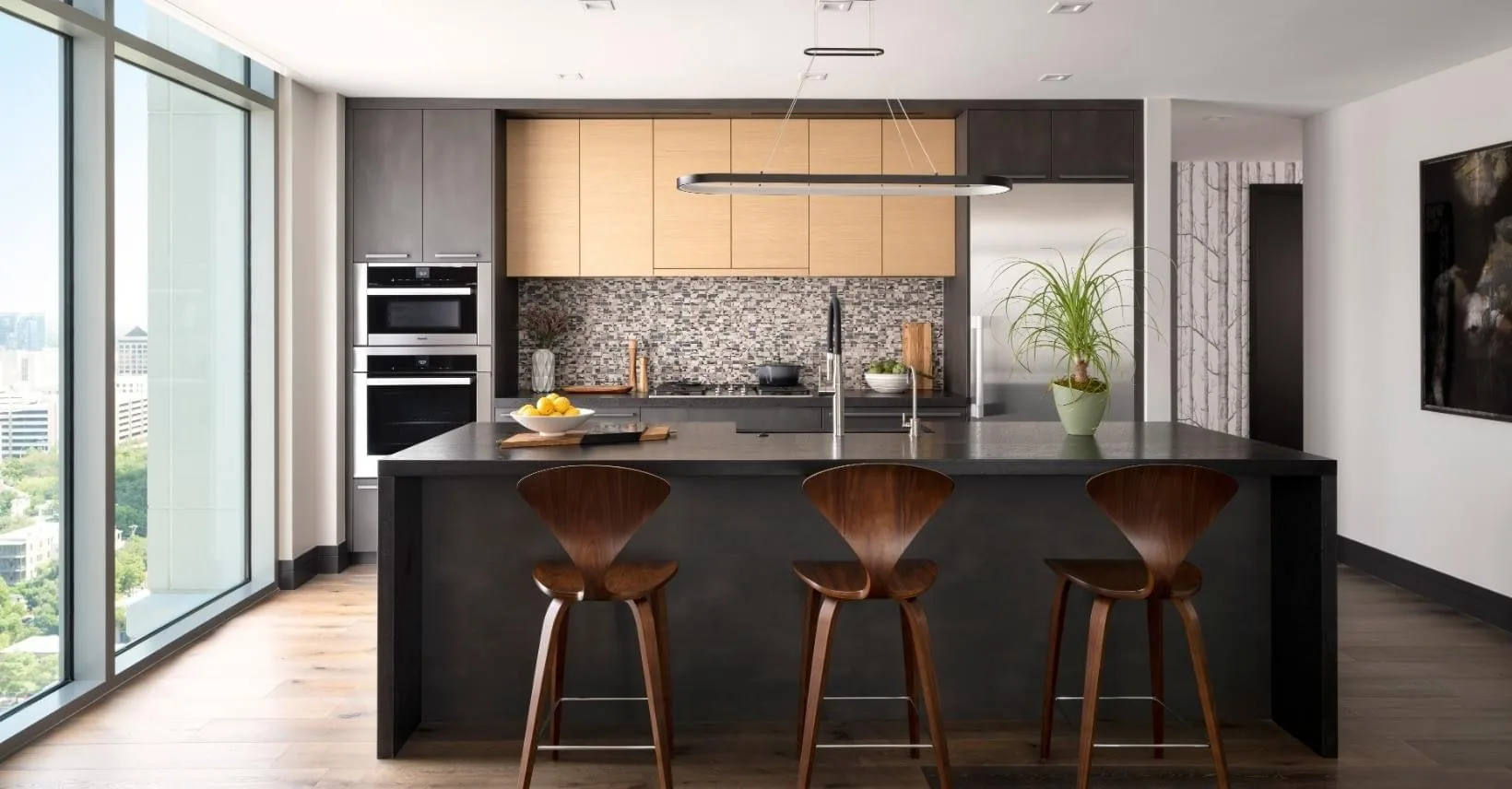 Modern kitchen with a dark island and floor-to-ceiling windows