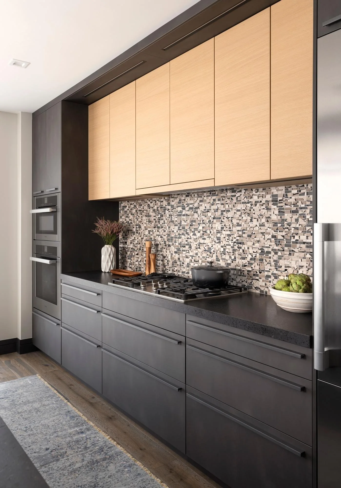 Dark modern kitchen with white oak cabinetry and mosaic backsplash at the 5th and West Condo